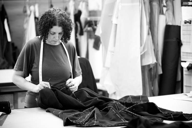 A female seamstress stitches a garment